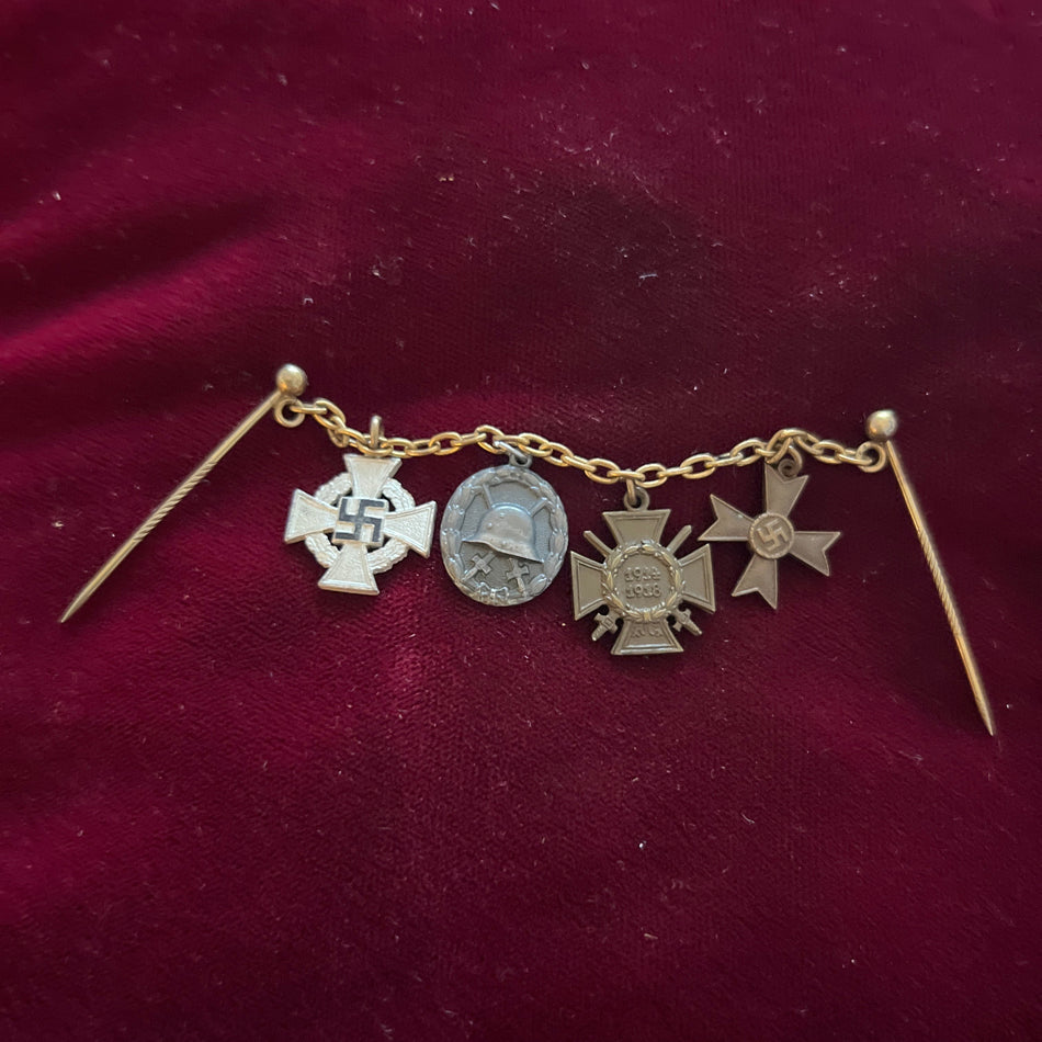 Miniature Nazi Germany group of 4 on chain - Cross of Honour 1914-1918, Wound Badge (silver grade), War Merit Cross (civil), and 25-Year Faithful Service Cross